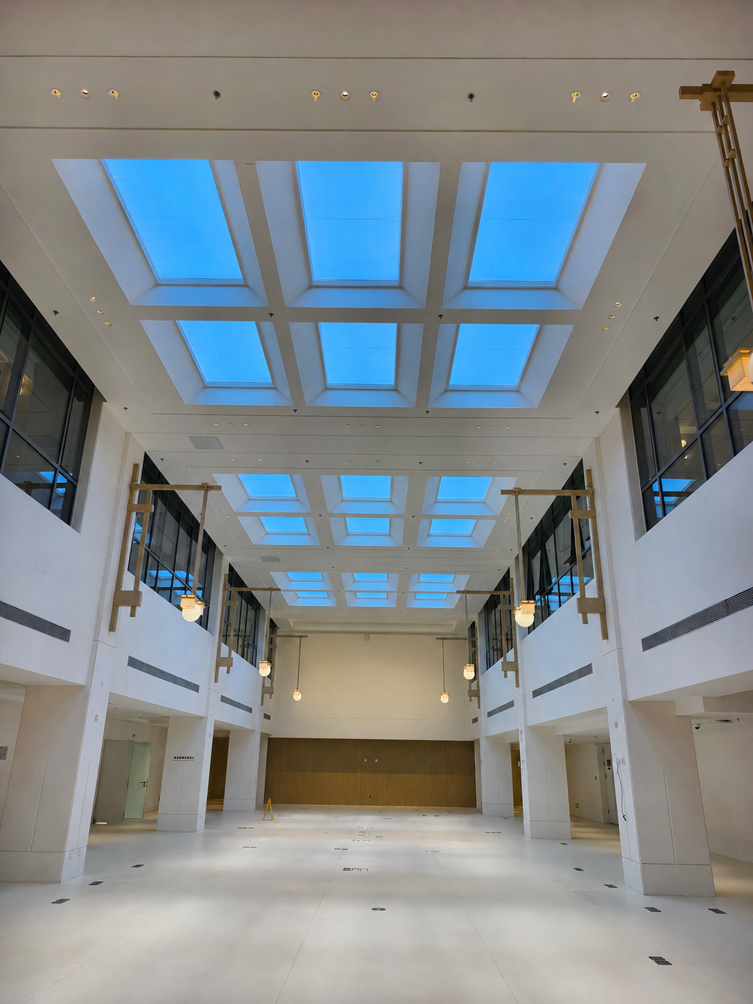 Multi-storey atrium lit by a grid of blue sky artificial skylights