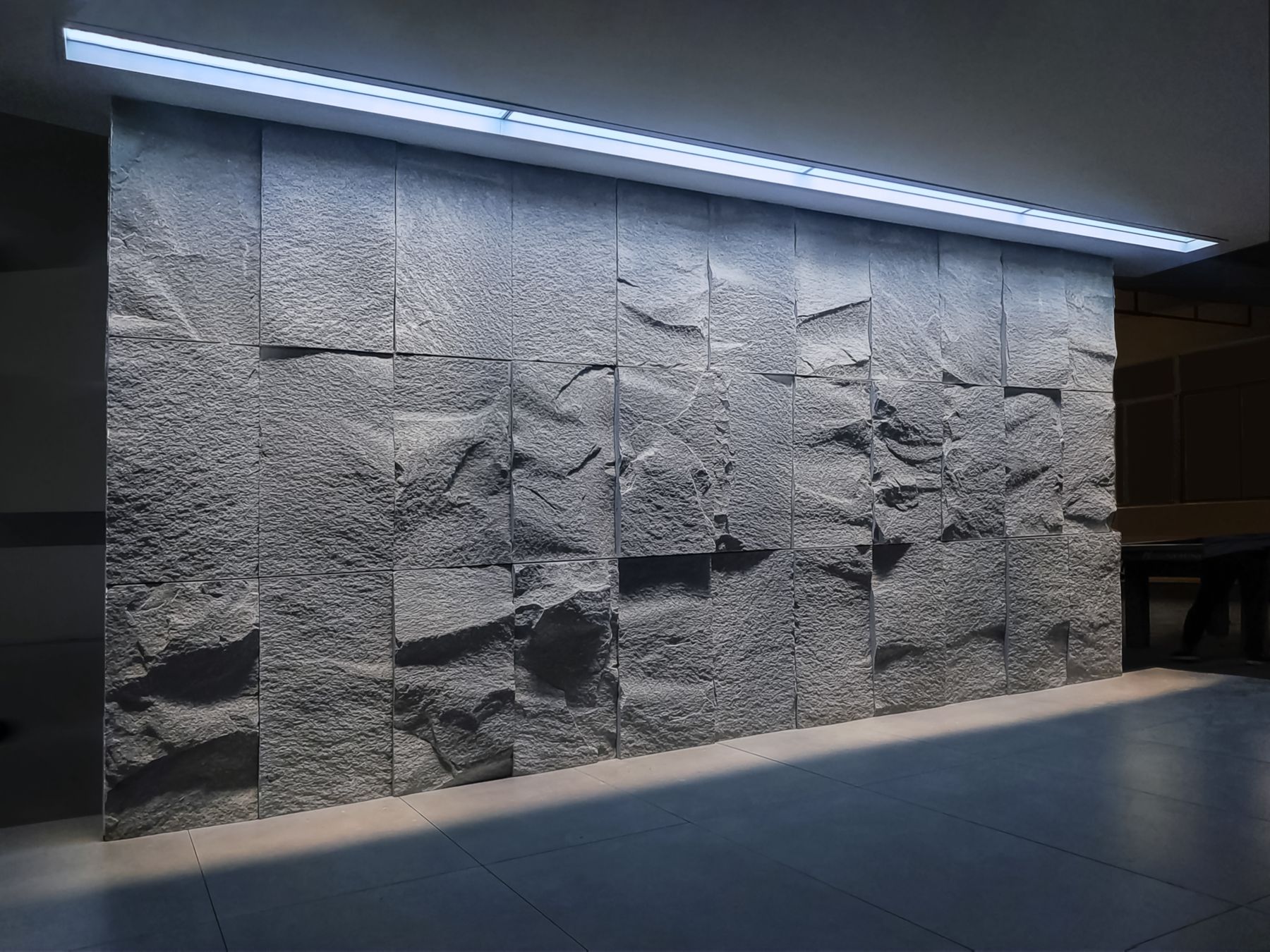 Linear artificial skylight wall-washing a feature wall
